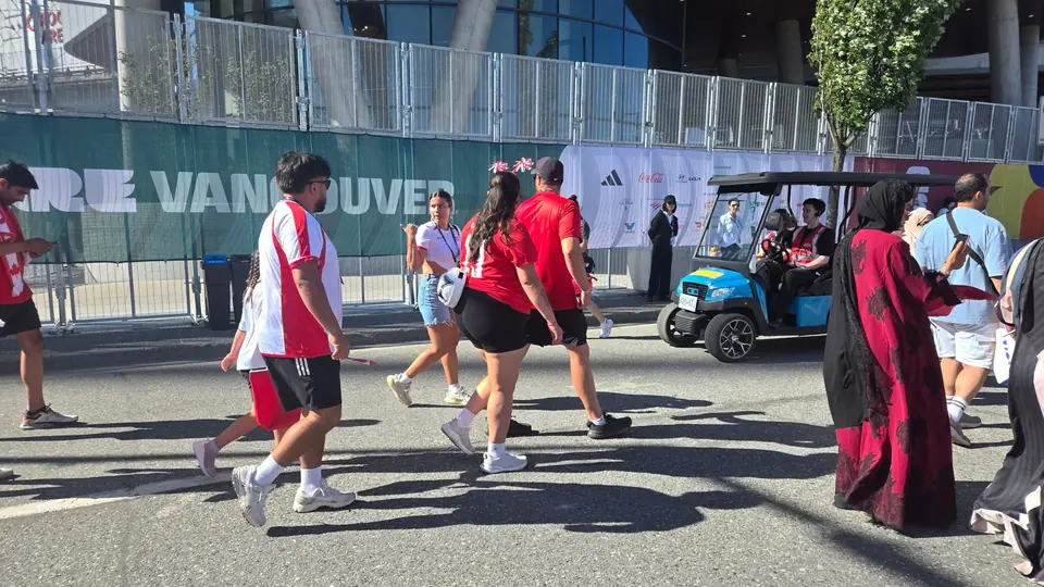 A HeyYa cart with event staff aboard near a busy crowd outside a Vancouver stadium