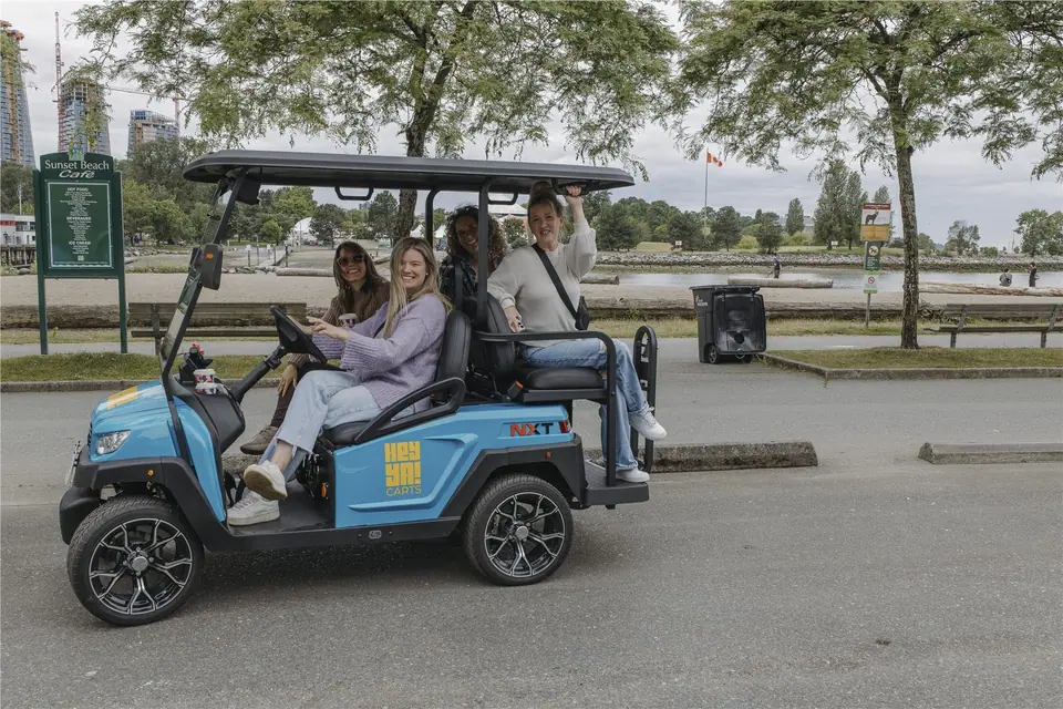 Four friends riding a HeyYa cart past Sunset Beach