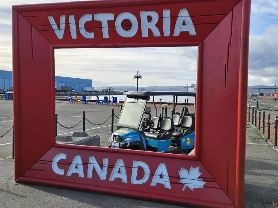A HeyYa cart framed by the red Victoria Canada sign at the harbour