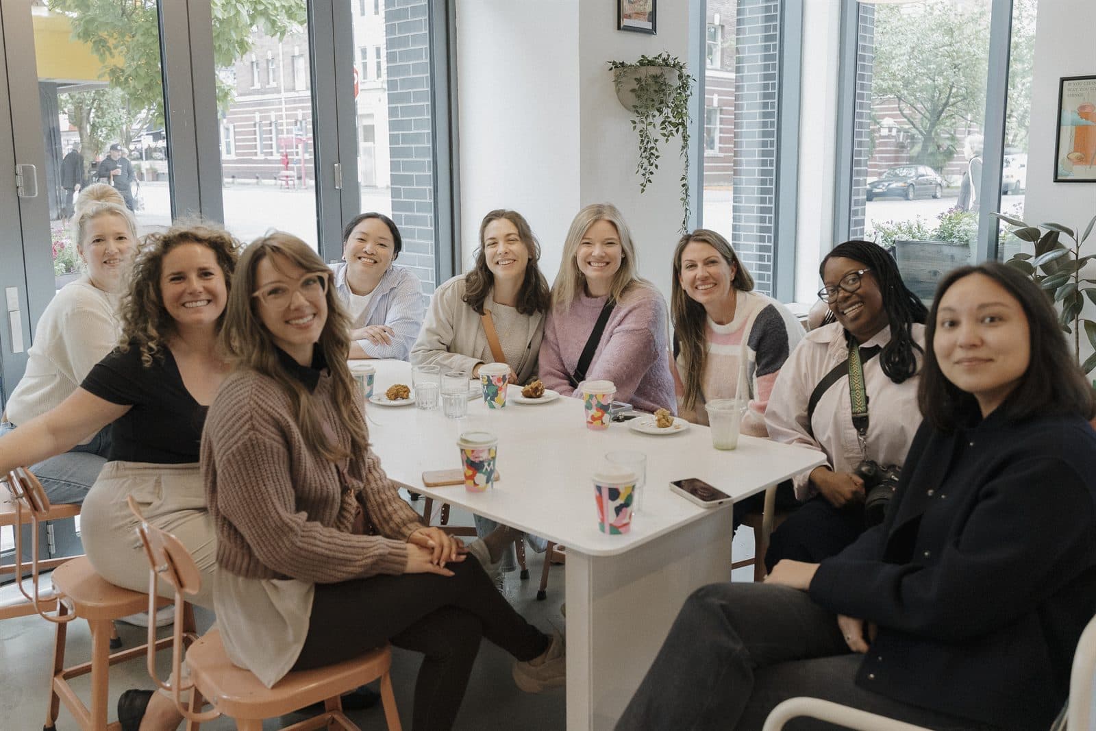 A group of friends smiling around a café table