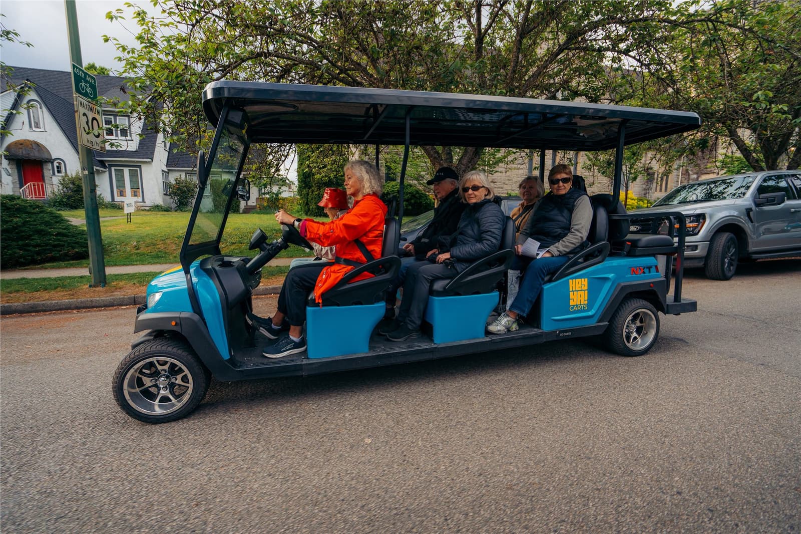 Passengers enjoying a community outing in a blue HeyYa cart